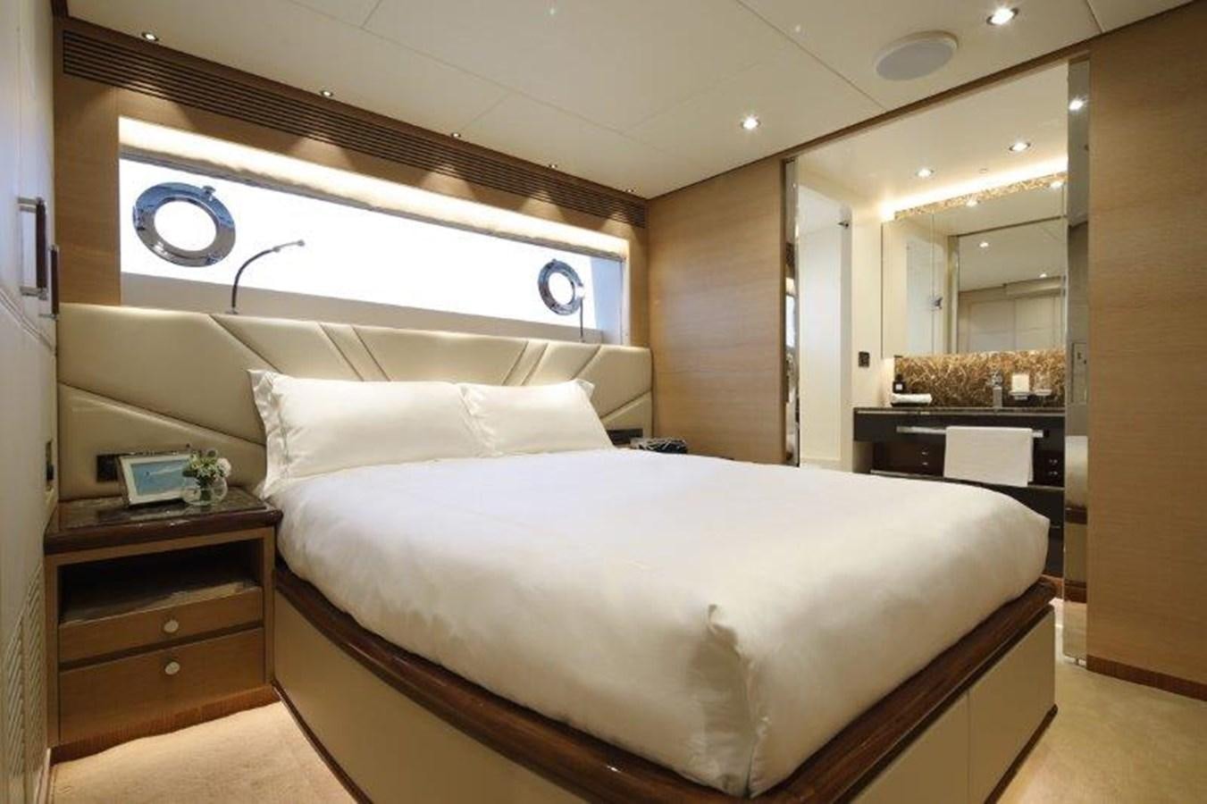 a bedroom with a bed and a desk aboard CROWNED EAGLE Yacht for Sale