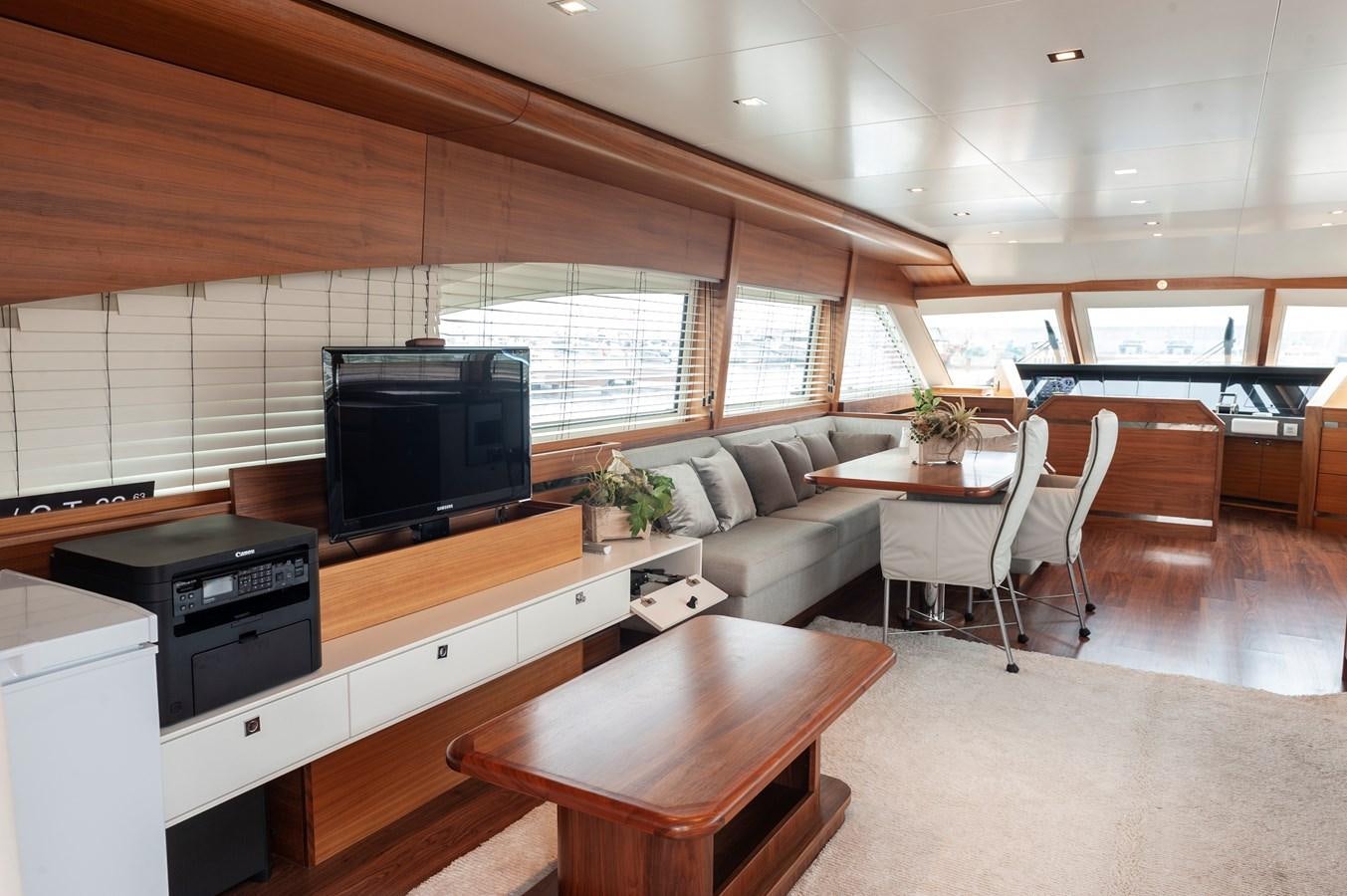 a living room with a tv and a table aboard ANGELS Yacht for Sale