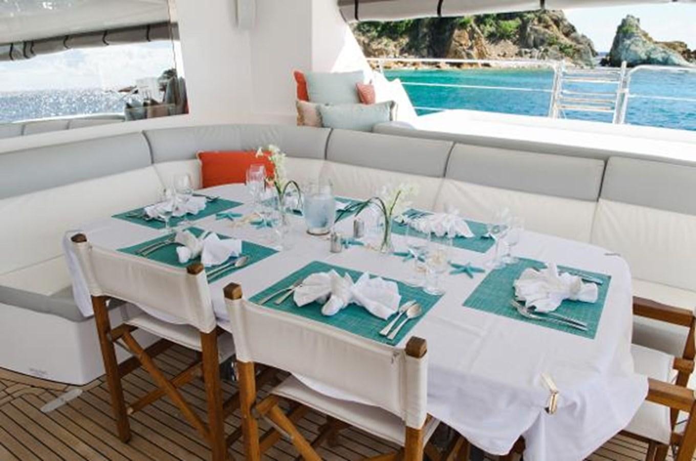 a table with chairs and a pool aboard 74' PRIVILEGE 2010 Yacht for Sale