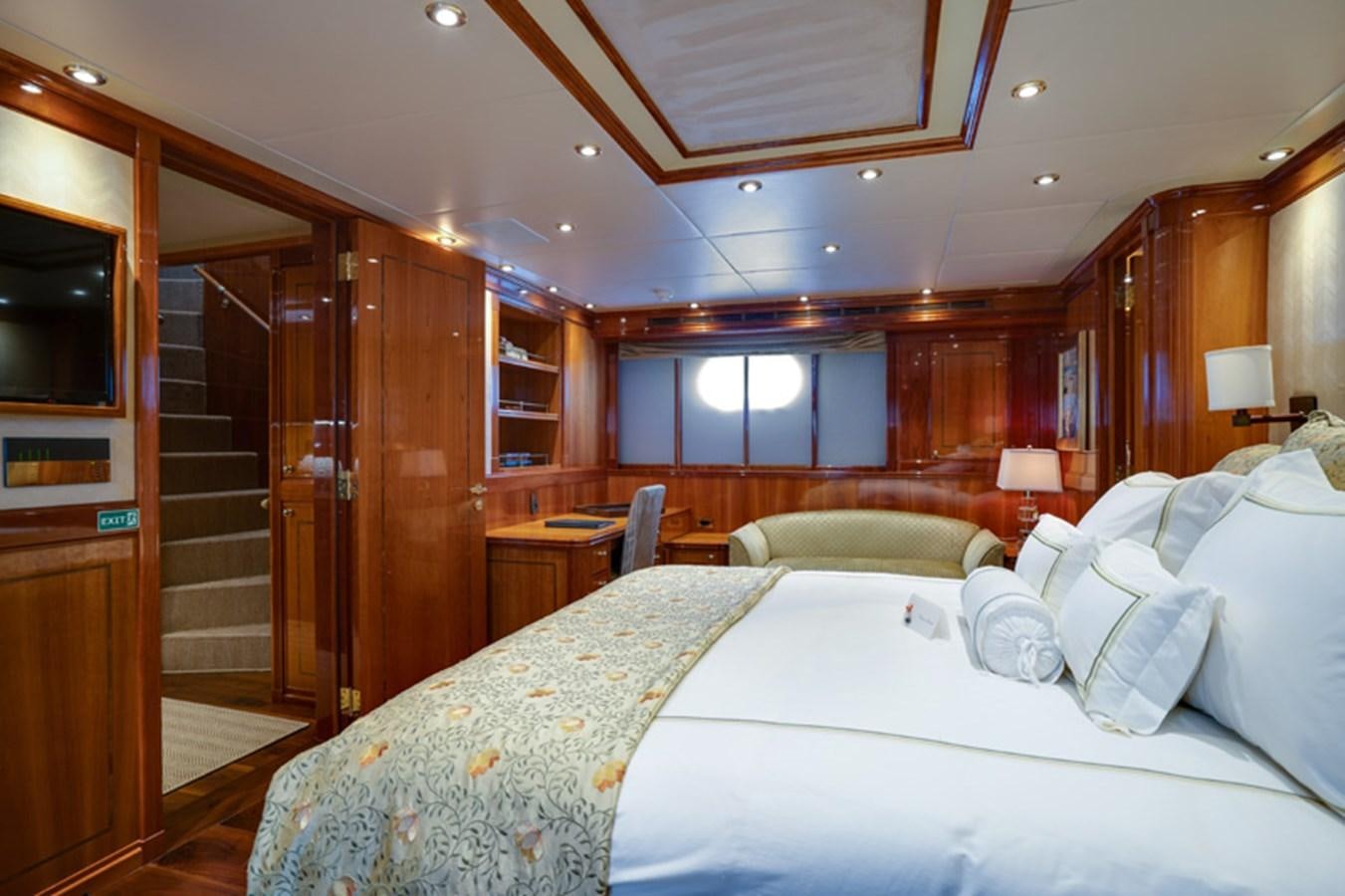 a room with a bed and a wood cabinet aboard TEMPTATION Yacht for Sale
