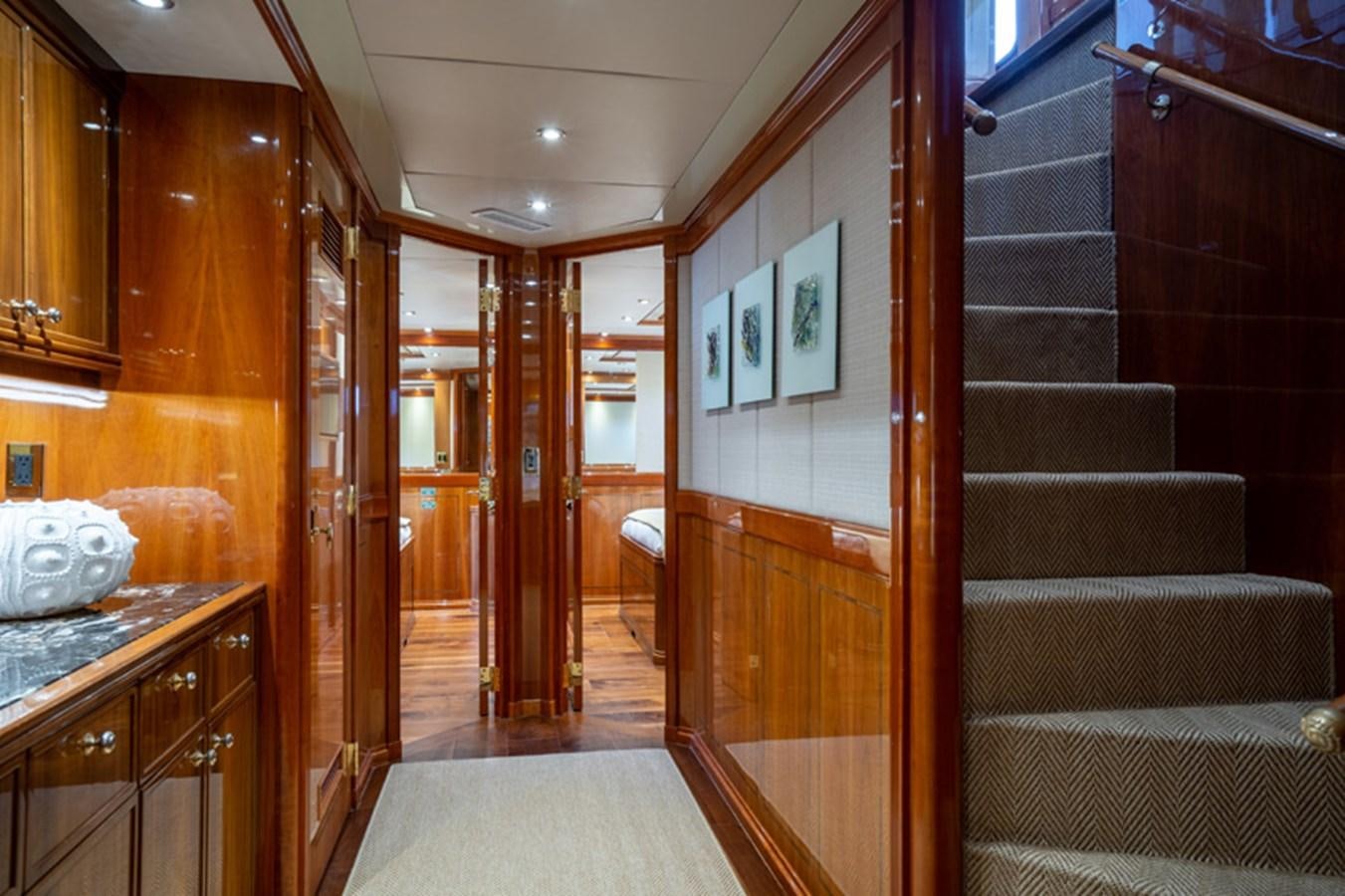 a room with wood cabinets and a staircase aboard TEMPTATION Yacht for Sale