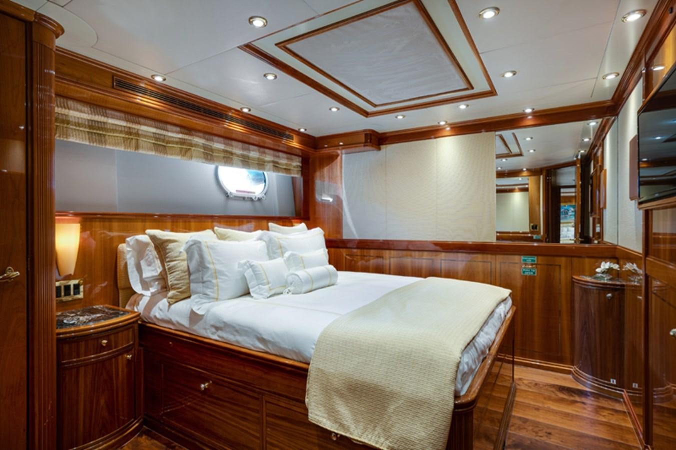 a room with a bed and a mirror aboard TEMPTATION Yacht for Sale