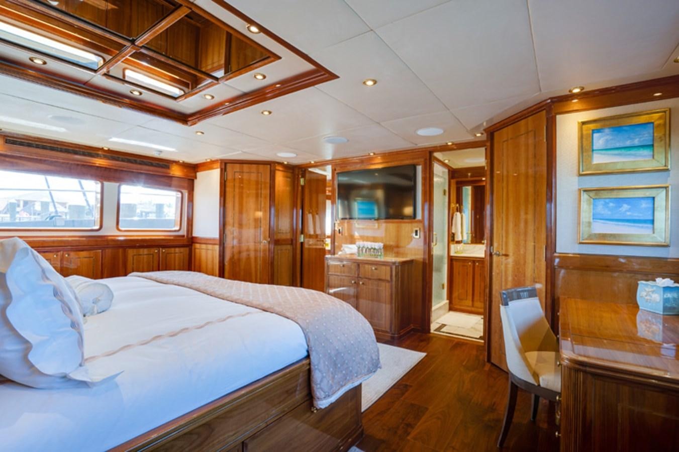 a bedroom with a bed and a desk aboard TEMPTATION Yacht for Sale