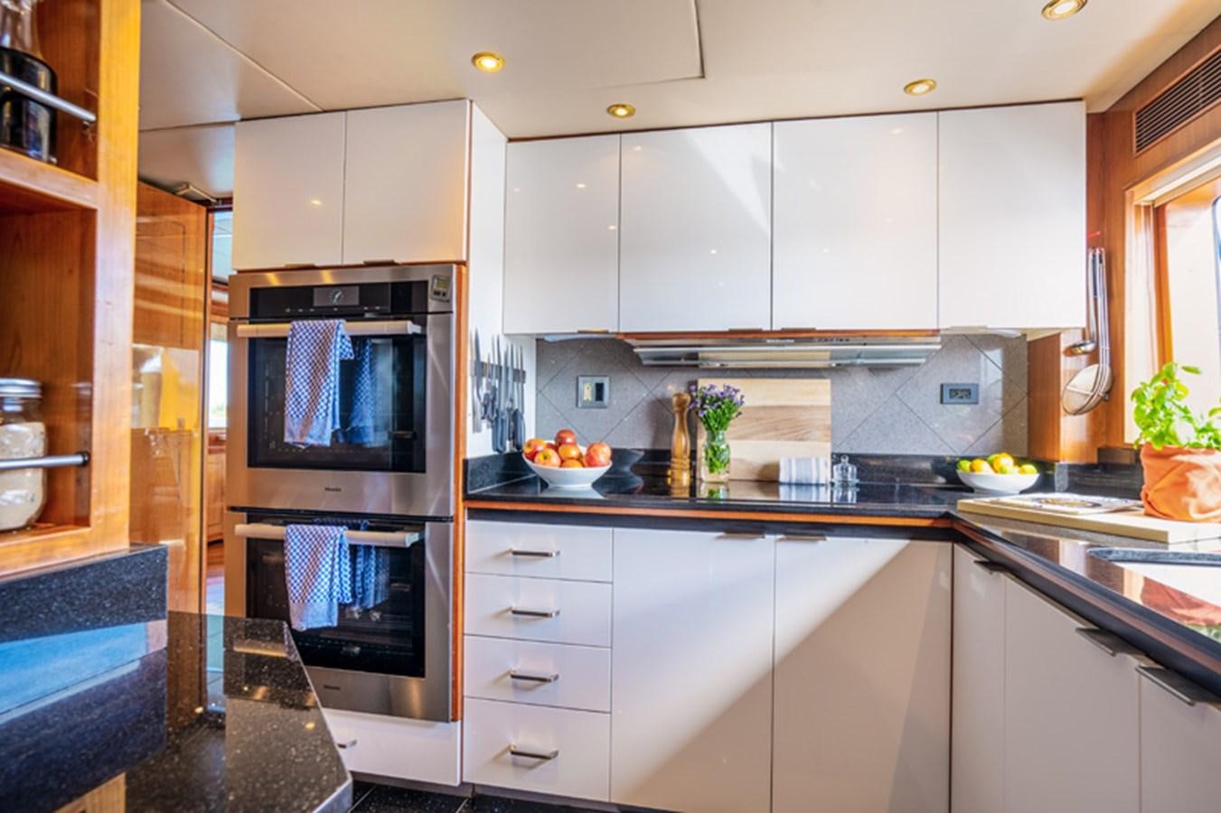 a kitchen with white cabinets aboard TEMPTATION Yacht for Sale