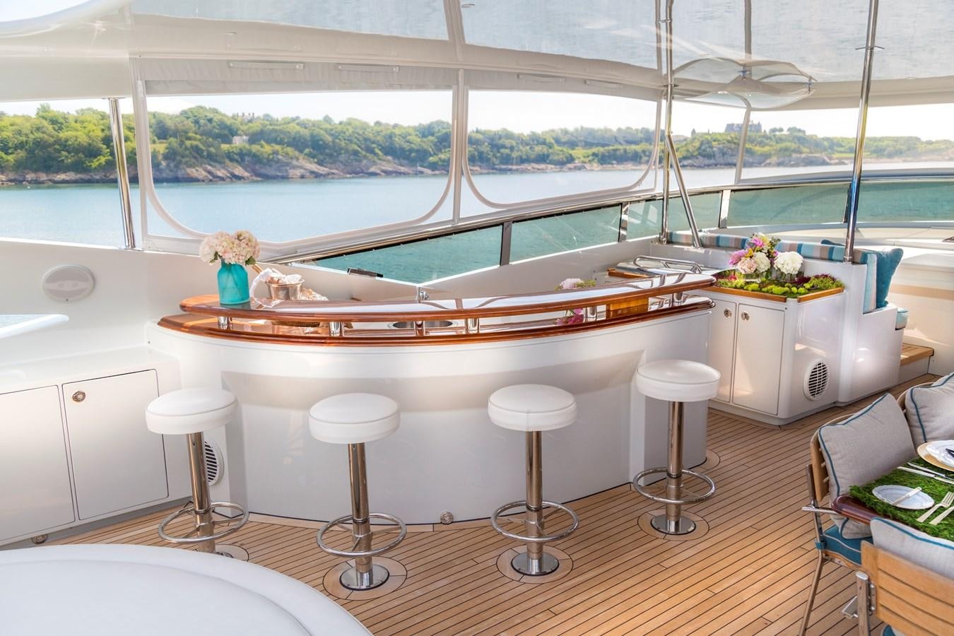 a table with stools and a window overlooking a body of water aboard TEMPTATION Yacht for Sale