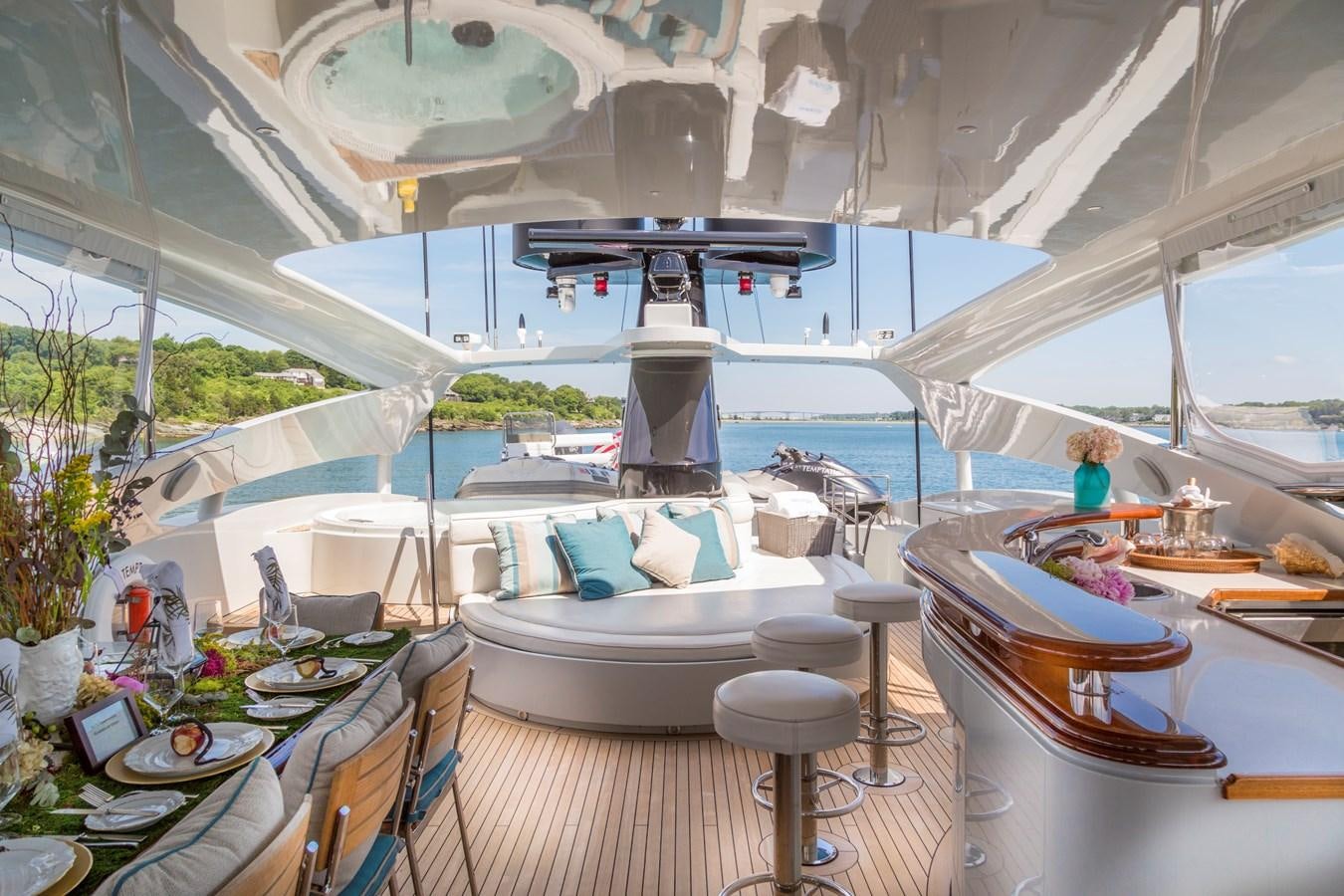 a large white tent with a table and chairs and a person sitting on the floor aboard TEMPTATION Yacht for Sale