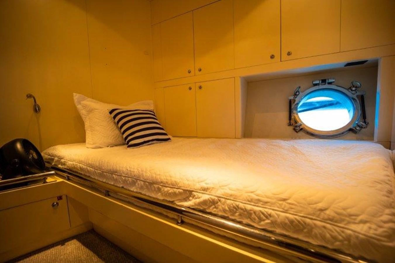 a bed with a round mirror above it aboard NYHAVEN Yacht for Sale