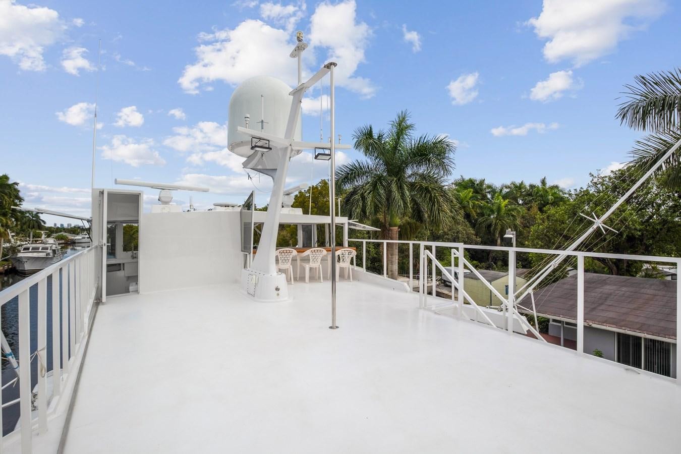 a white building with a white fence and trees and blue sky aboard MOVIE SET Yacht for Sale