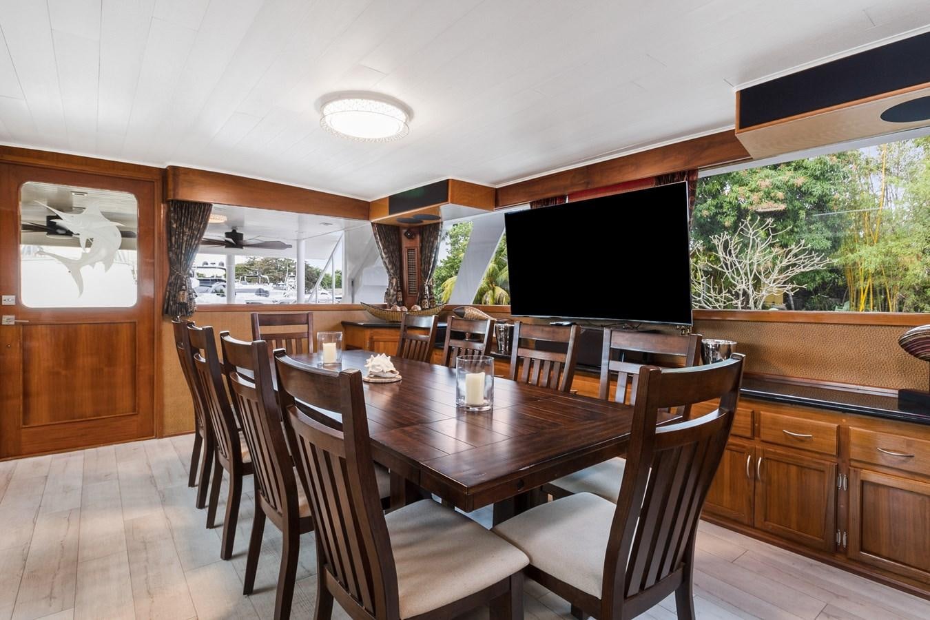 a dining room with a large screen aboard MOVIE SET Yacht for Sale