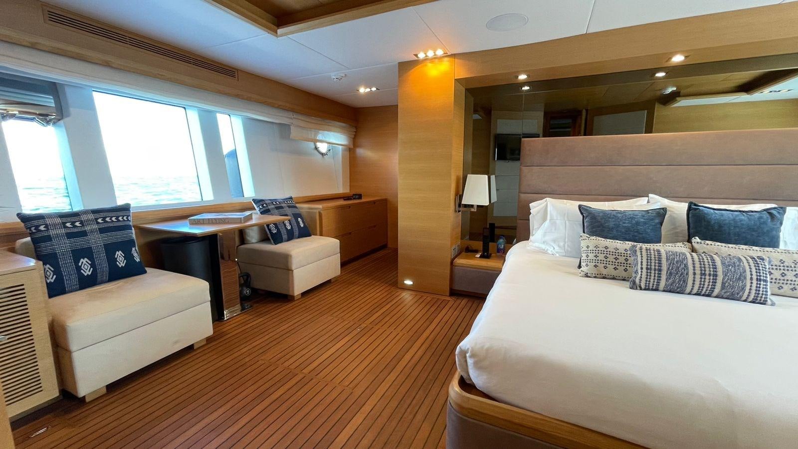 a room with a bed and a couch aboard VICTORIOUS Yacht for Sale