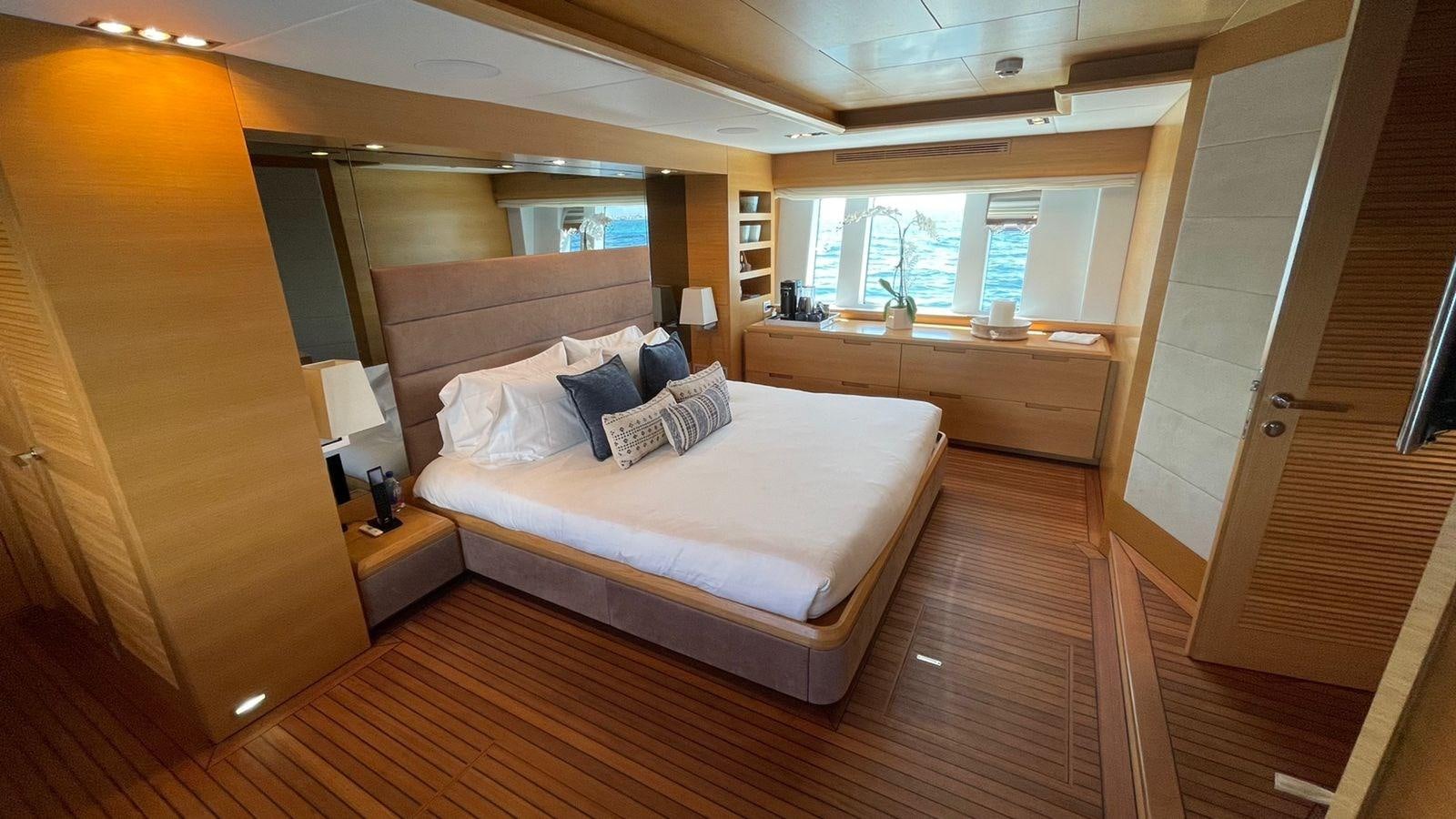 a room with a bed and a desk aboard VICTORIOUS Yacht for Sale