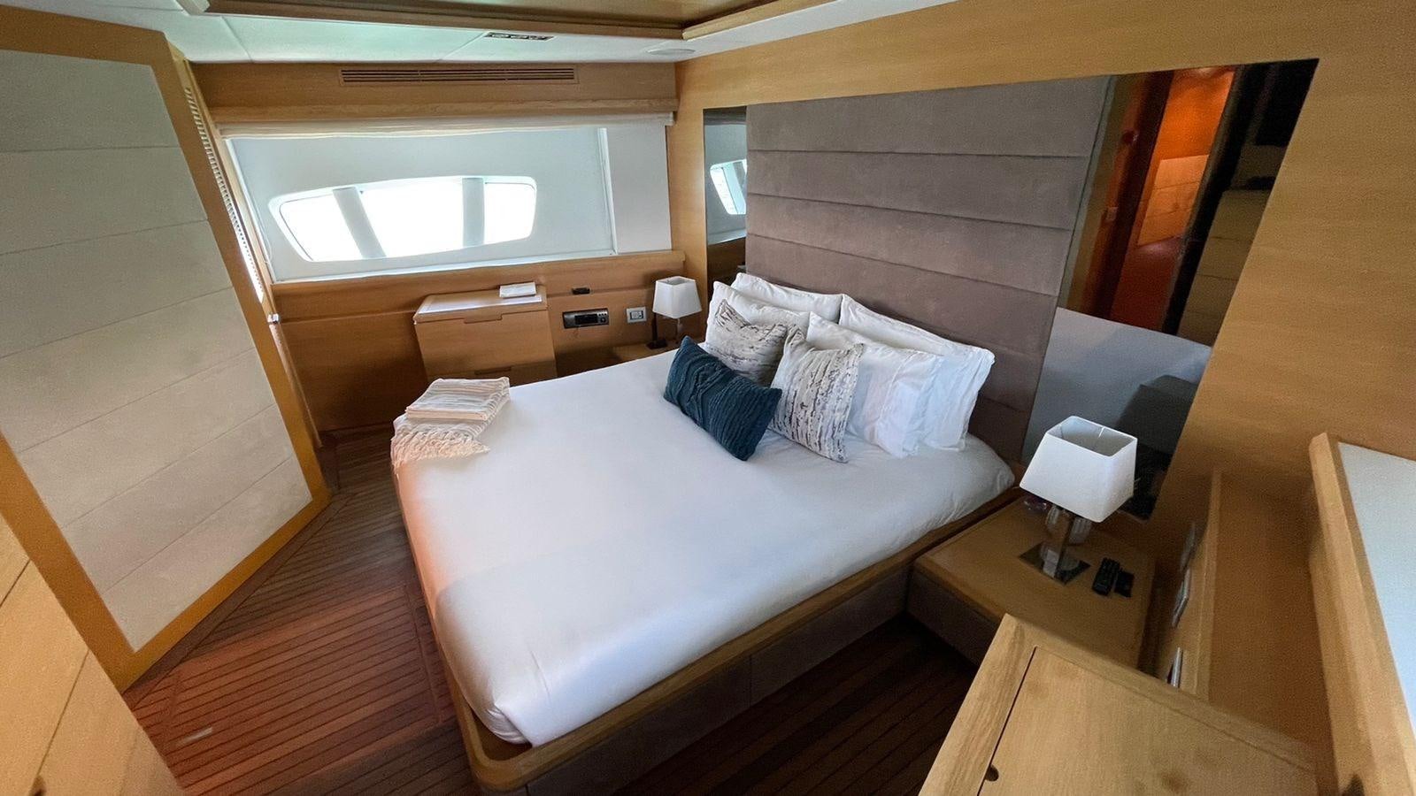 a room with a bed and a window aboard VICTORIOUS Yacht for Sale