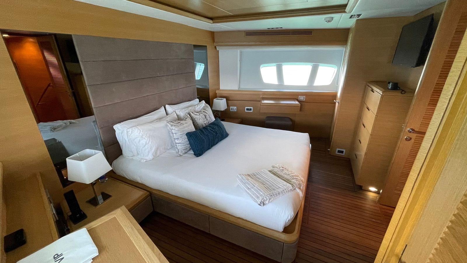 a room with a bed and a desk aboard VICTORIOUS Yacht for Sale