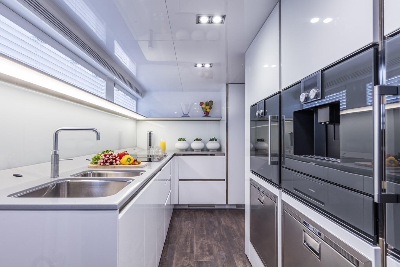 a kitchen with black appliances aboard AMIRA Yacht for Sale
