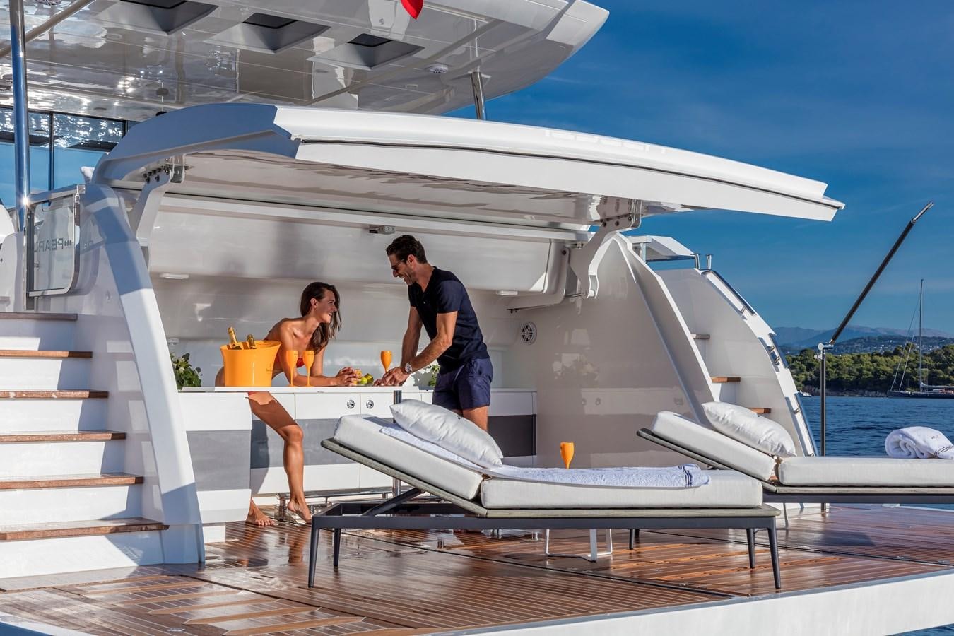 a man and woman standing next to a white boat aboard AMIRA Yacht for Sale