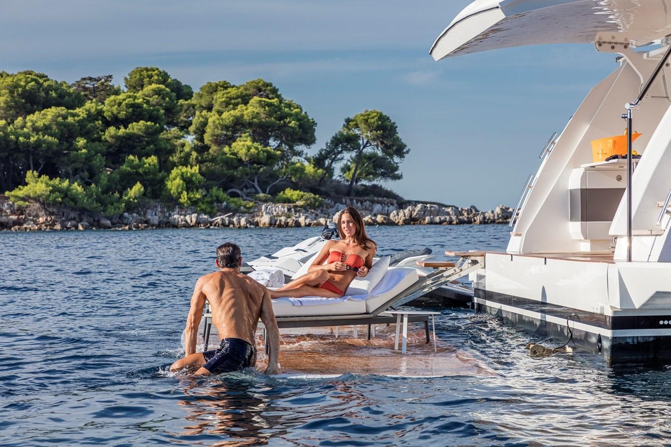a man and woman sitting in a boat in the water aboard AMIRA Yacht for Sale