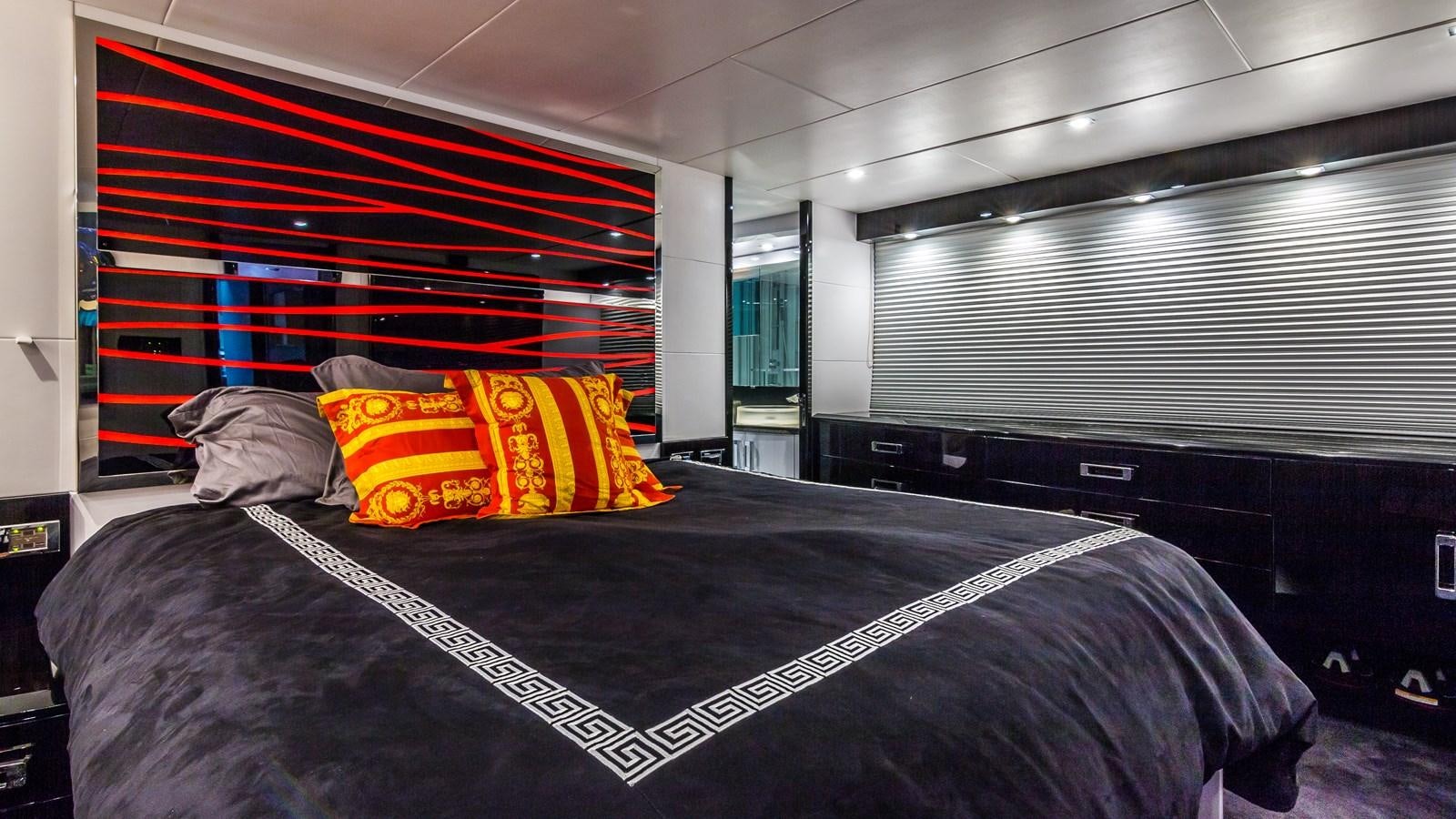 a bed with a black and red striped pillow aboard SEXY Yacht for Sale