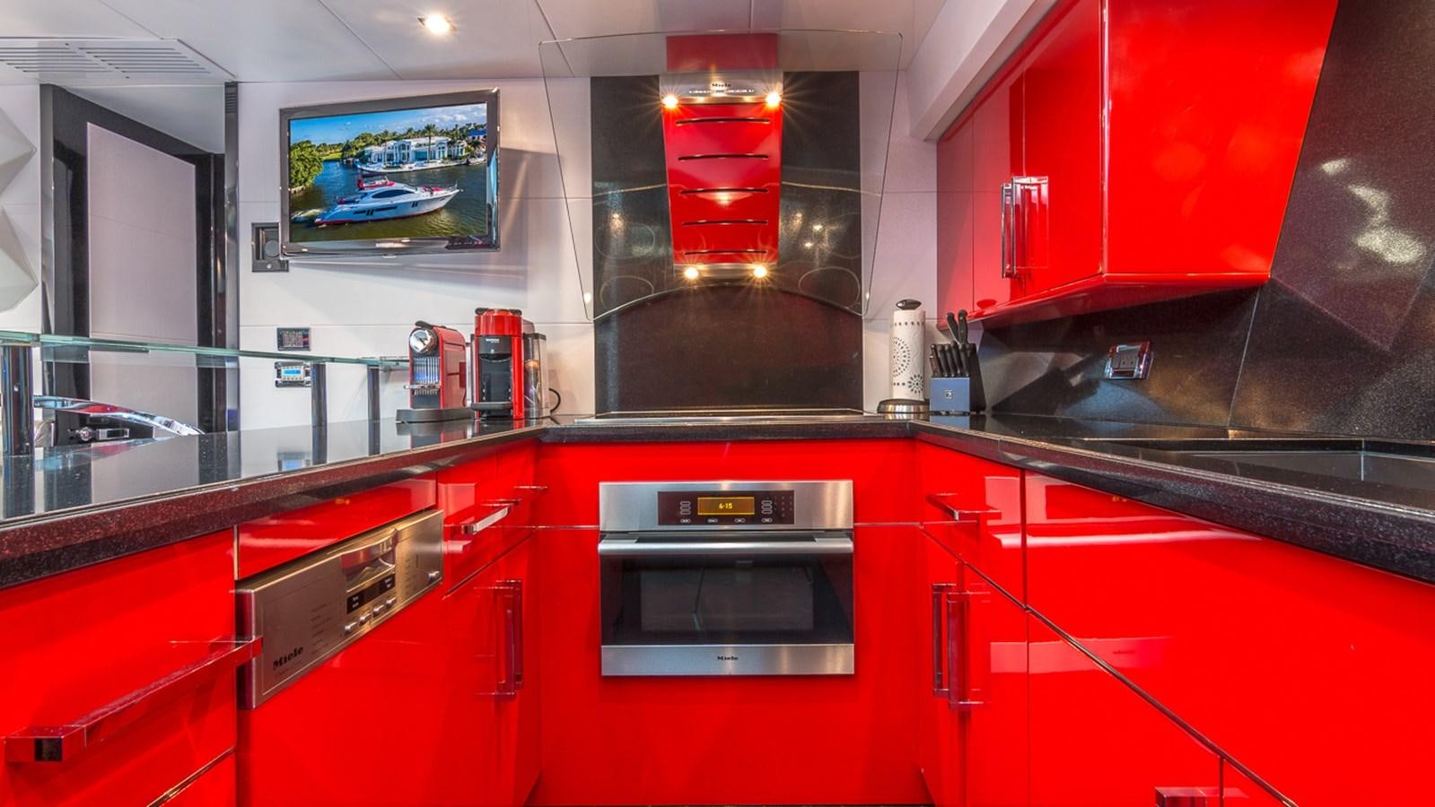 a kitchen with red cabinets aboard SEXY Yacht for Sale