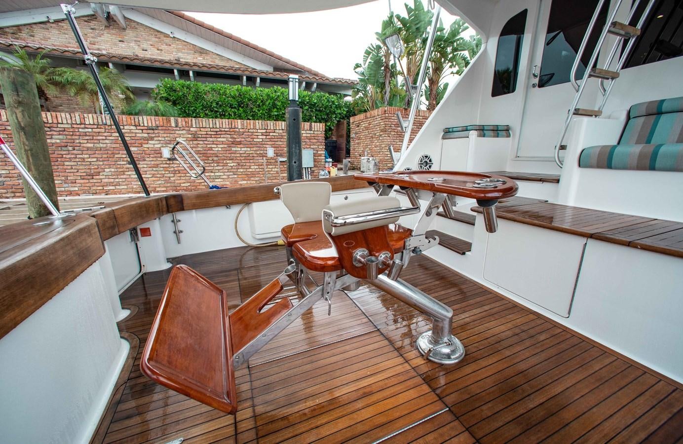 a deck with a table and chairs aboard CURIOUS GEORGE Yacht for Sale