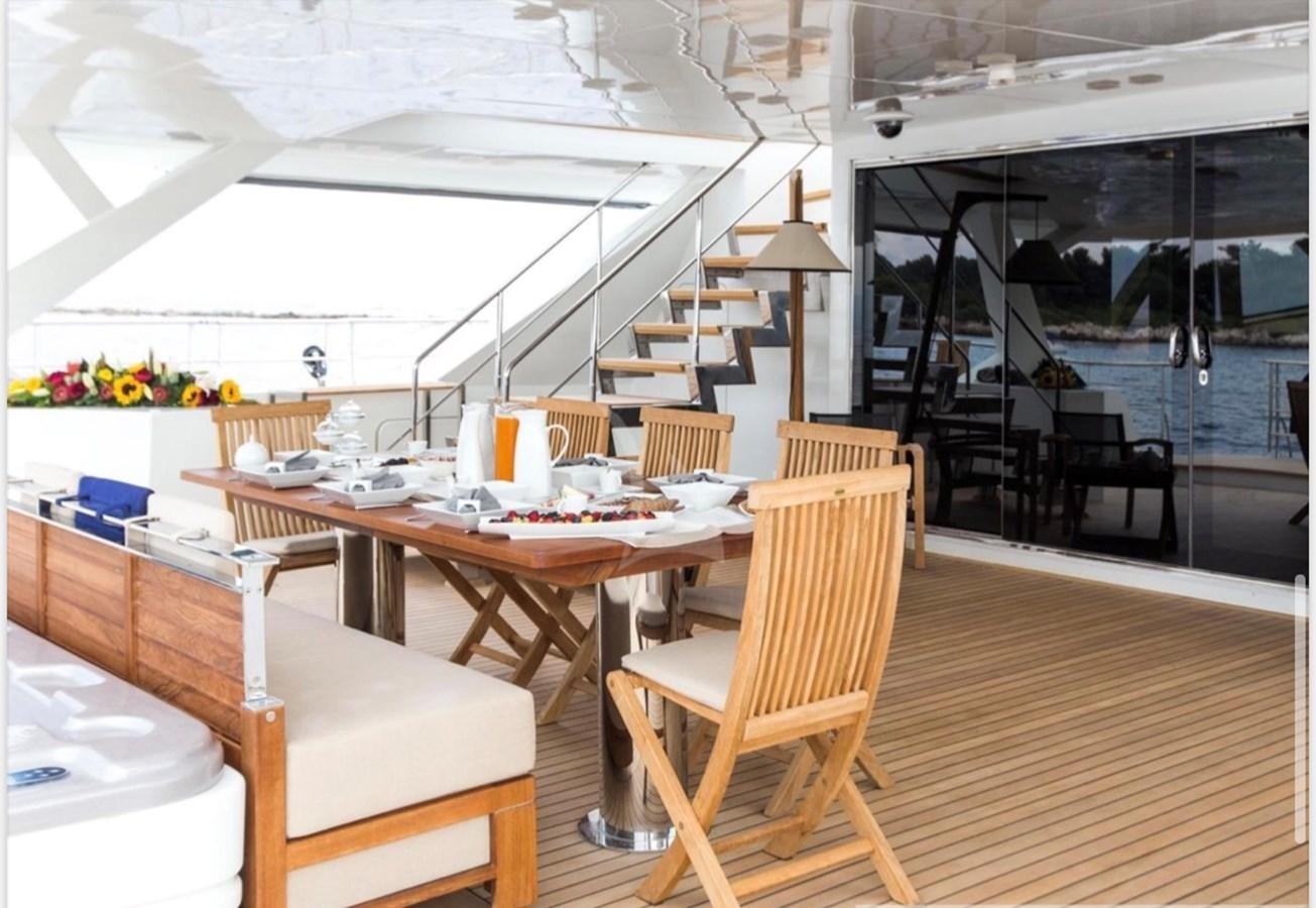 a room with tables and chairs aboard MANTANI Yacht for Sale