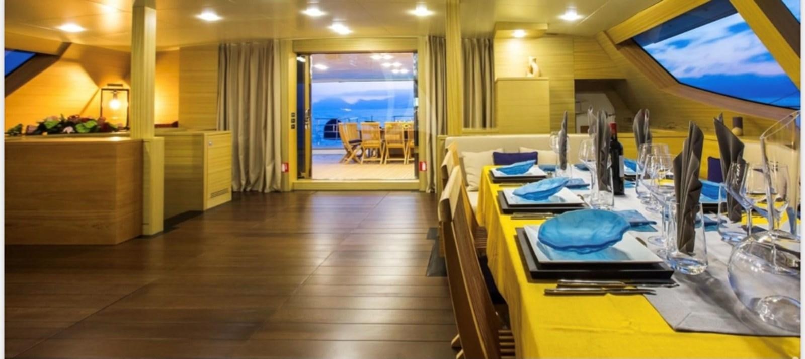 a large room with a table and chairs aboard MANTANI Yacht for Sale
