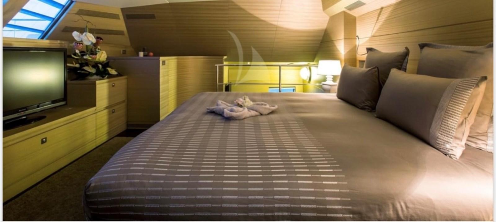 a bed with a television on the wall aboard MANTANI Yacht for Sale