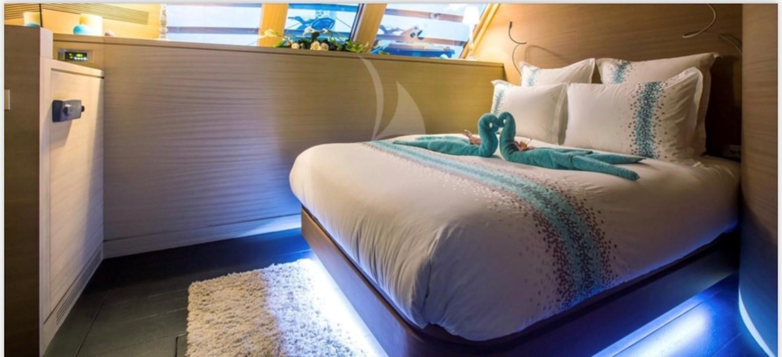 a bed with a blue sheet aboard MANTANI Yacht for Sale