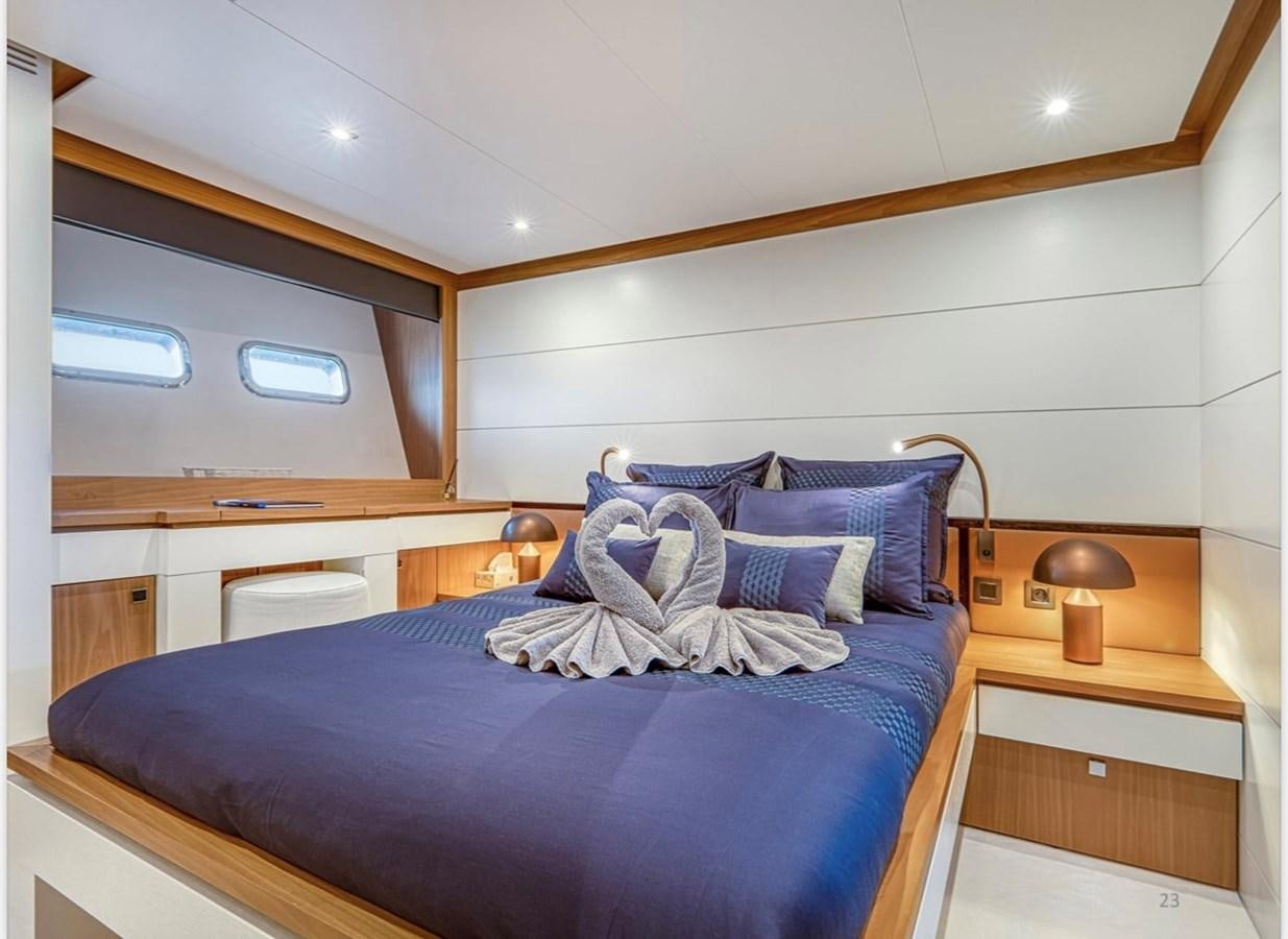 a bed with a blue comforter aboard MILLESIME Yacht for Charter