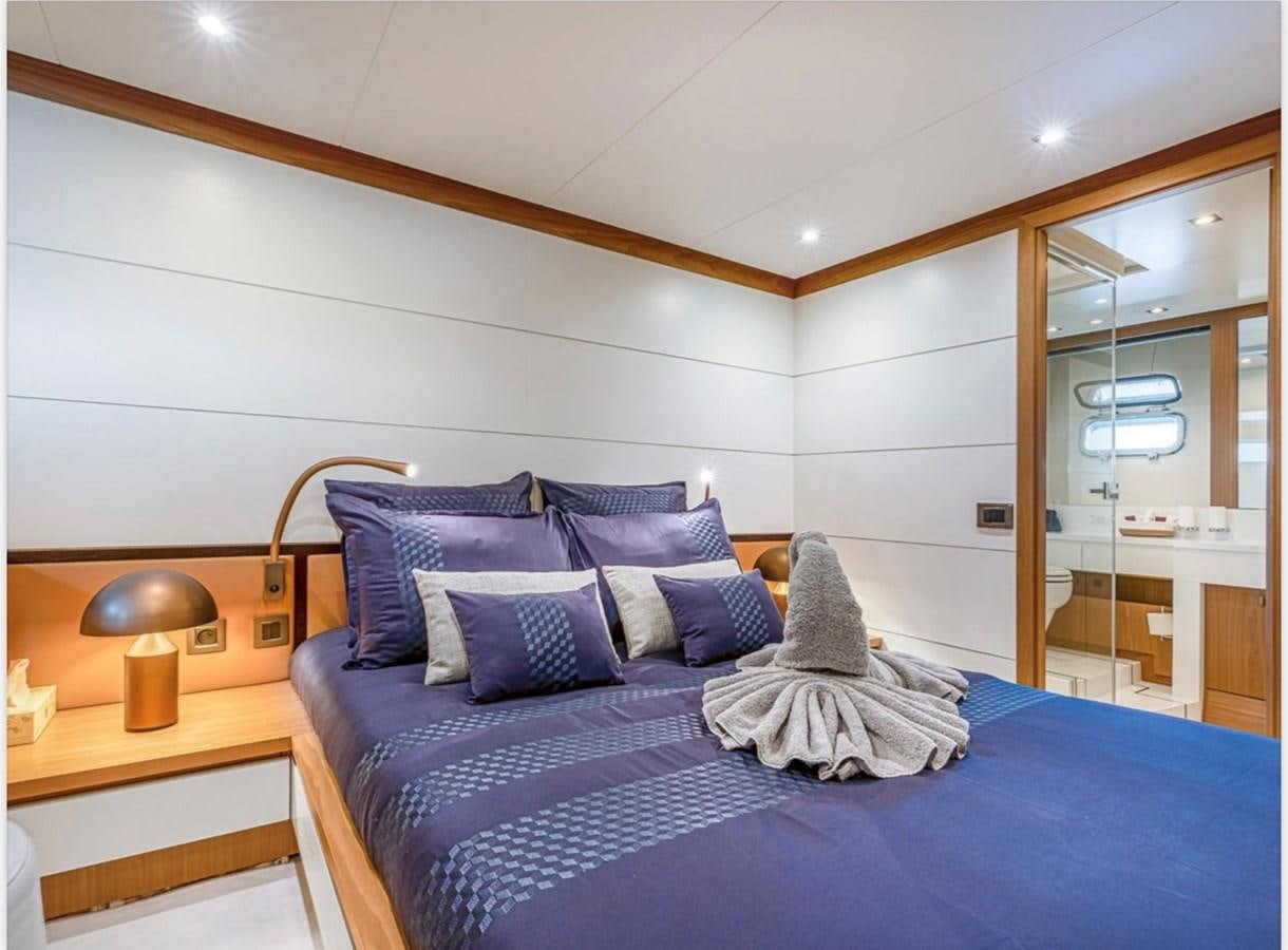 a bed with a blue comforter aboard MILLESIME Yacht for Charter