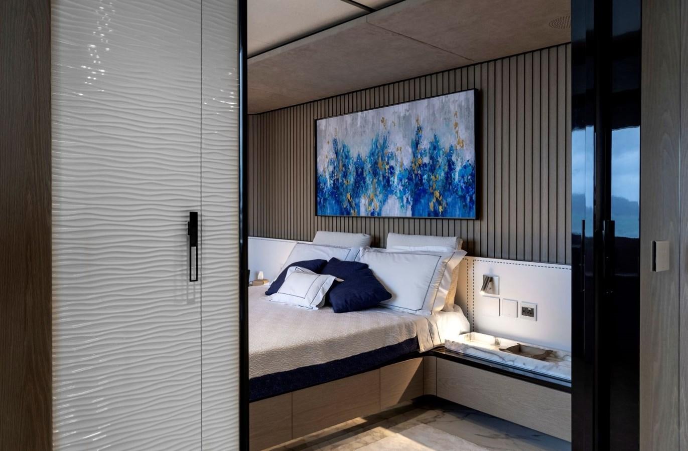 a room with a bed and a painting on the wall aboard C Yacht for Sale