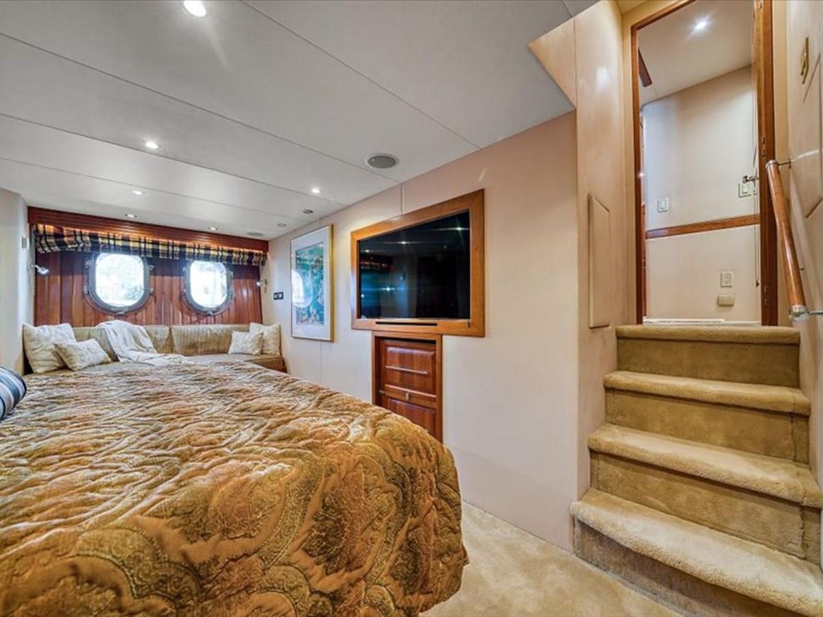 a bedroom with a bed and a tv on the wall aboard EVA VII Yacht for Sale