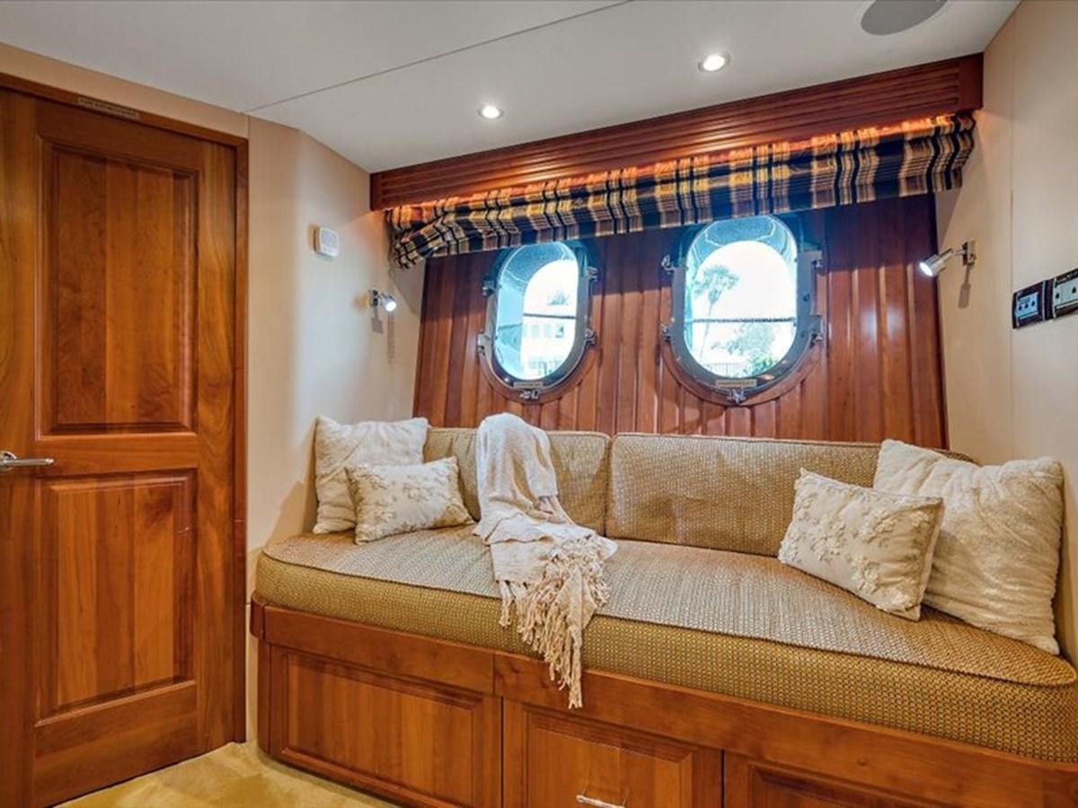 a couch with a window aboard EVA VII Yacht for Sale