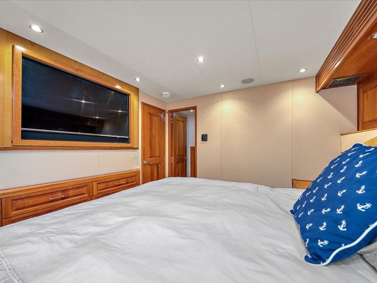 a bed with a white sheet and blue and white pillows aboard EVA VII Yacht for Sale