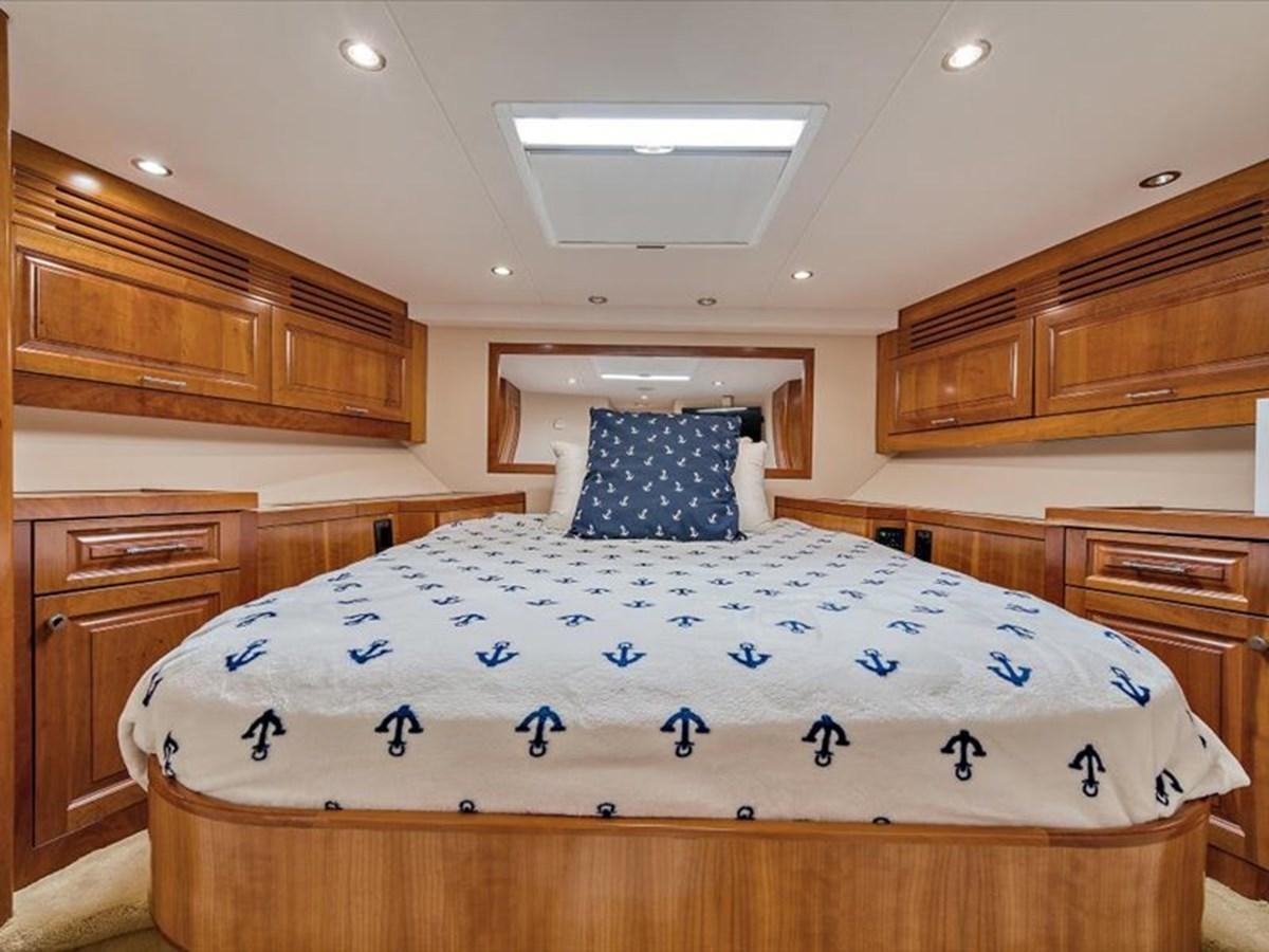 a bed with blue and white pillows aboard EVA VII Yacht for Sale