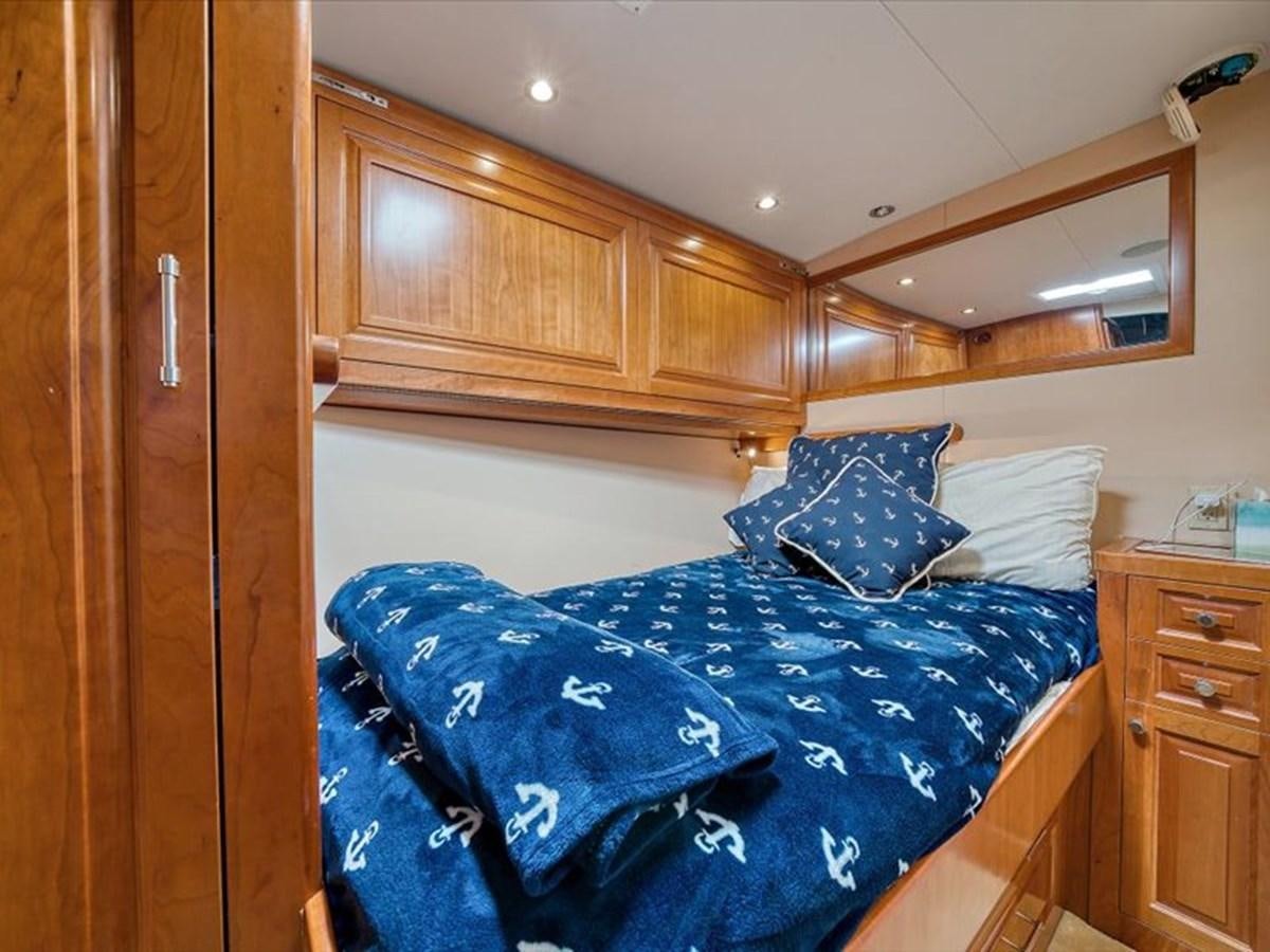 a bed with blue sheets aboard EVA VII Yacht for Sale