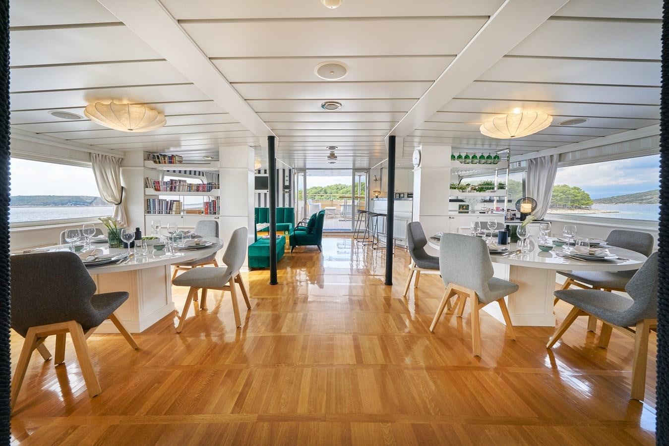 a room with a table chairs and a large window aboard LA PERLA Yacht for Charter