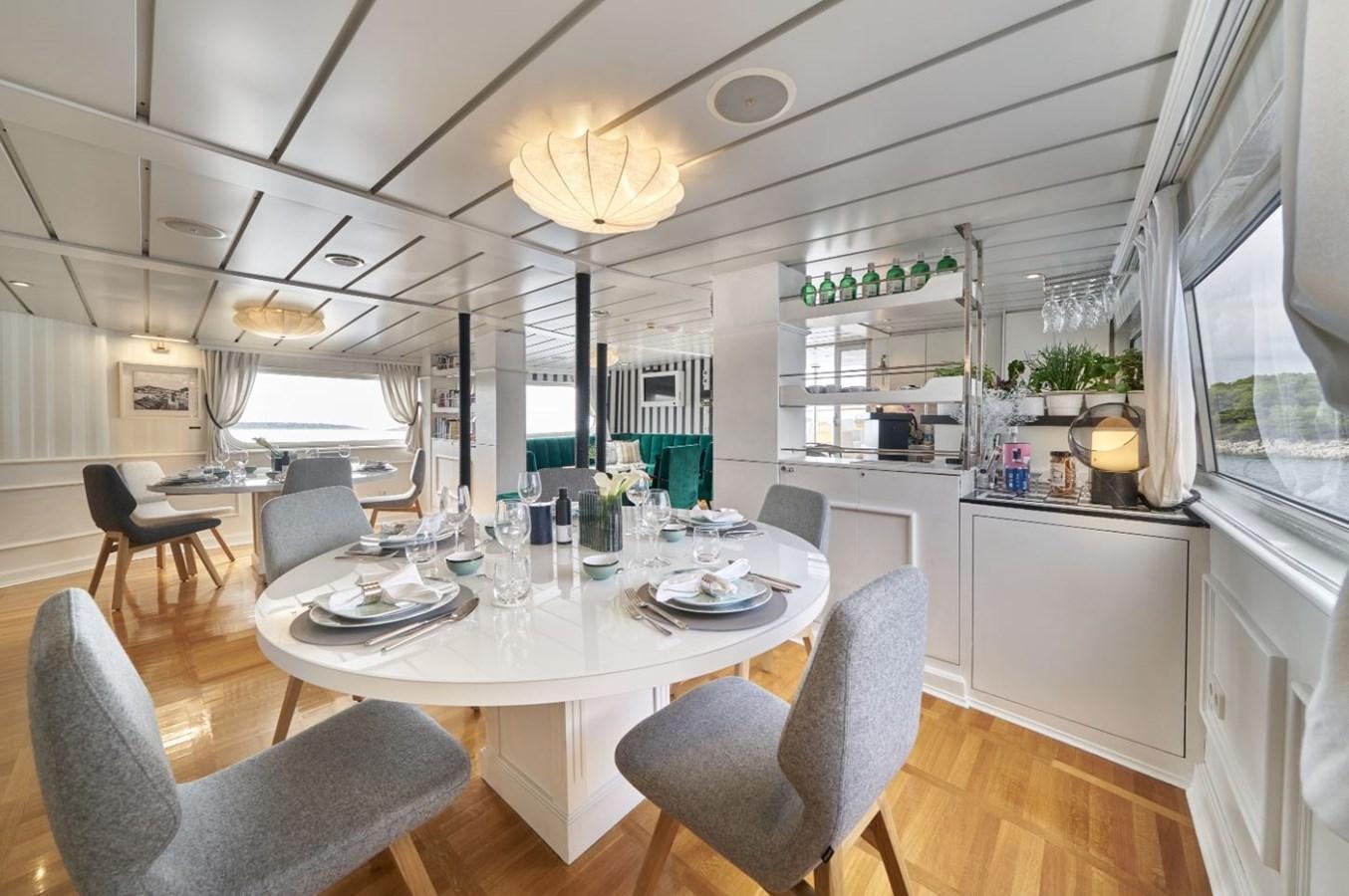 a large kitchen with a dining table aboard LA PERLA Yacht for Charter