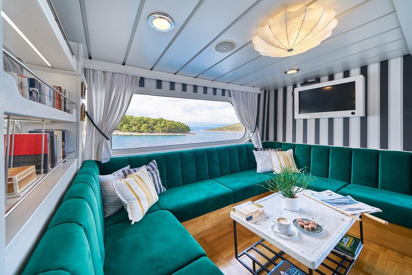 a living room with a couch and a table aboard LA PERLA Yacht for Charter