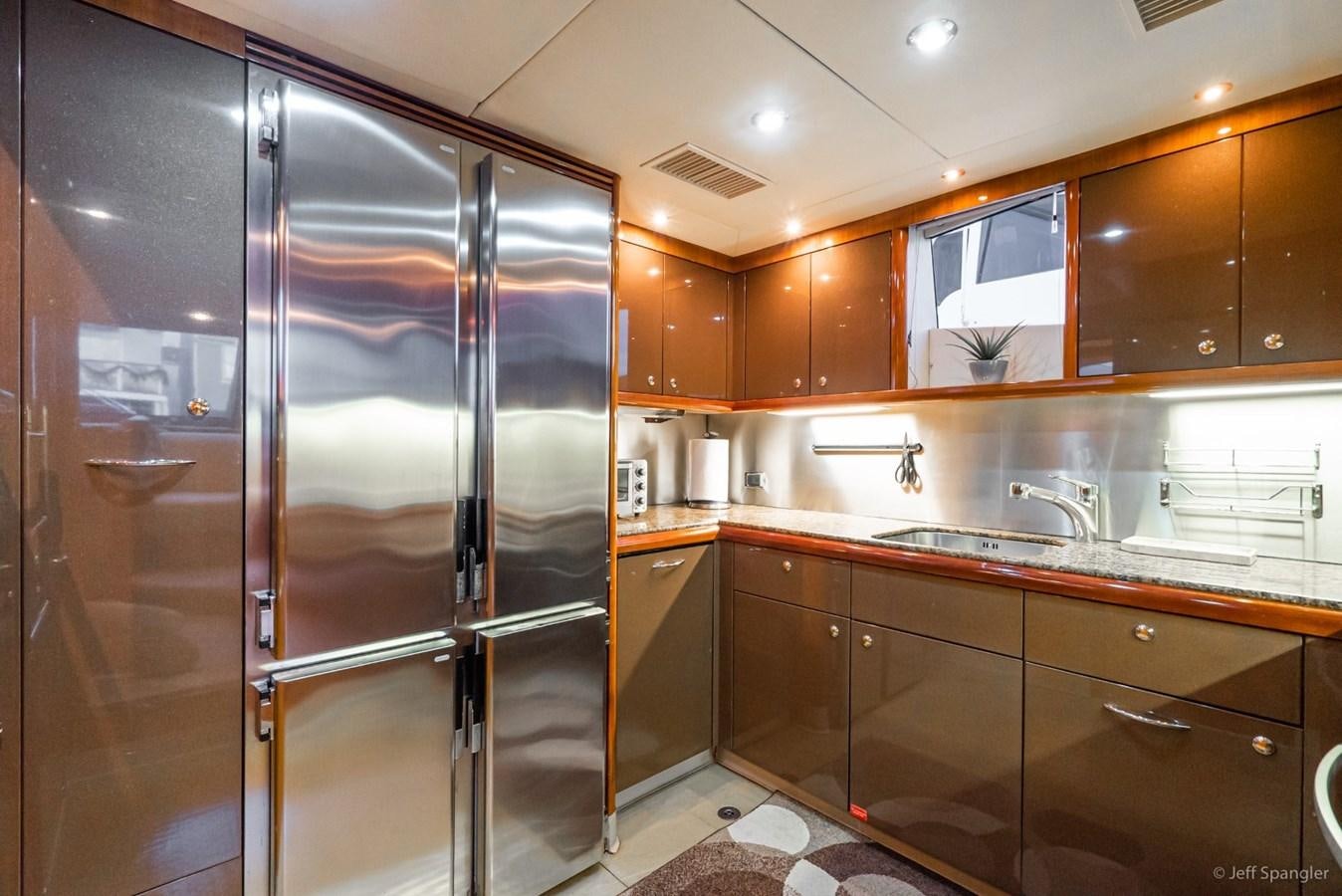 a kitchen with wooden cabinets aboard NAKOA Yacht for Sale
