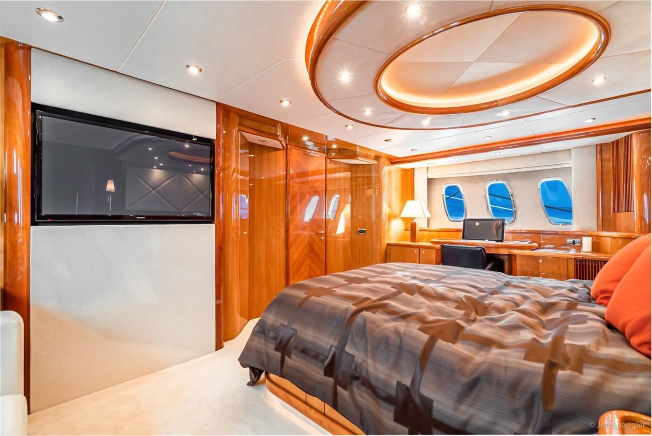 a room with a bed and a television aboard NAKOA Yacht for Sale