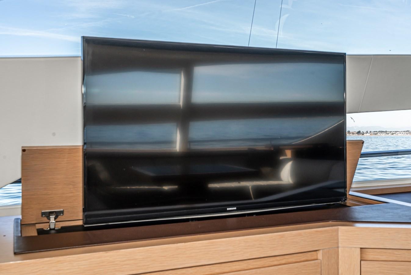 a black television on a wooden stand aboard MO T0WN Yacht for Sale