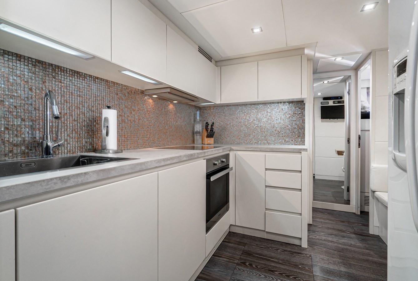 a kitchen with white cabinets aboard MO T0WN Yacht for Sale