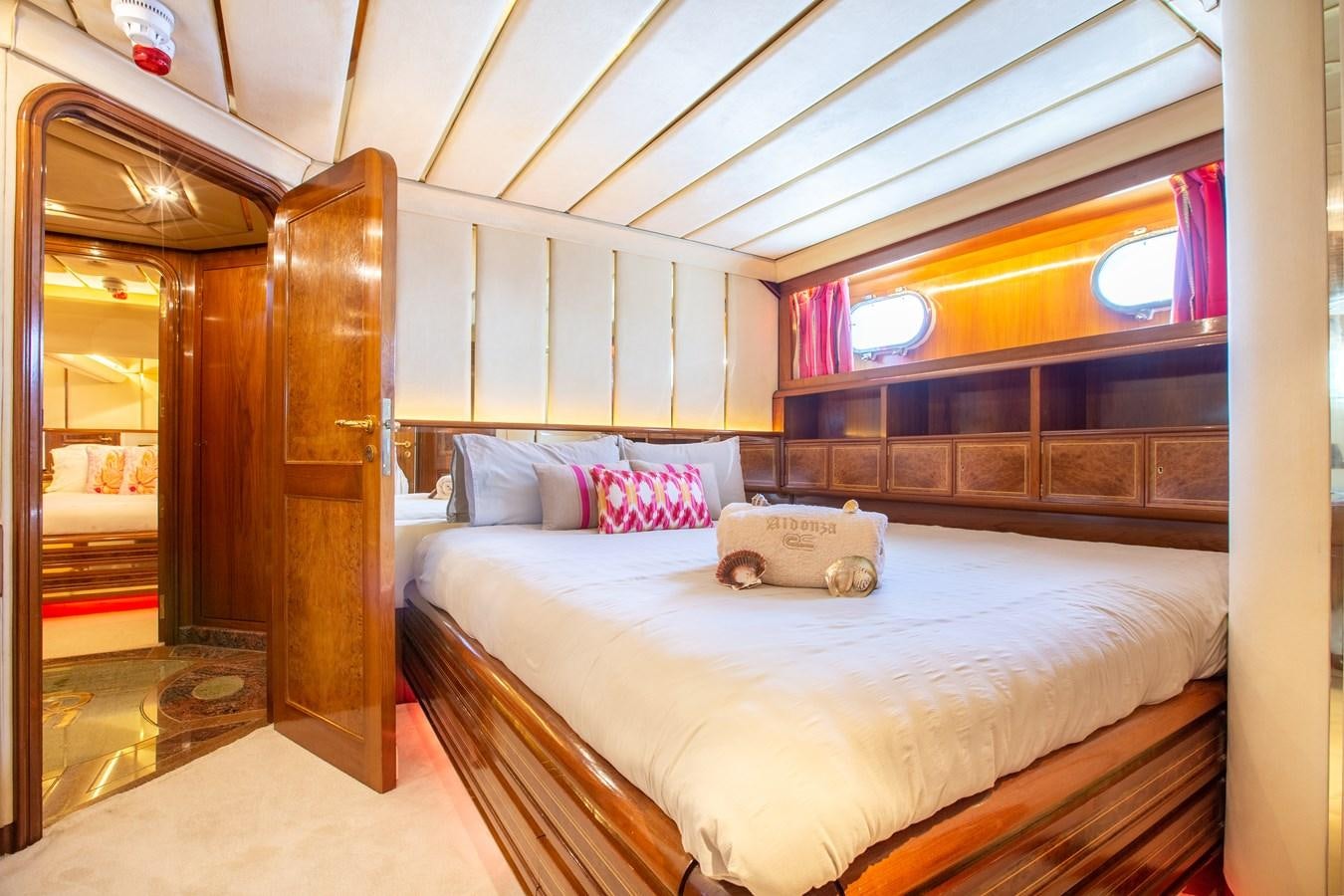 a bedroom with a bed and a wood door aboard ALDONZA Yacht for Sale