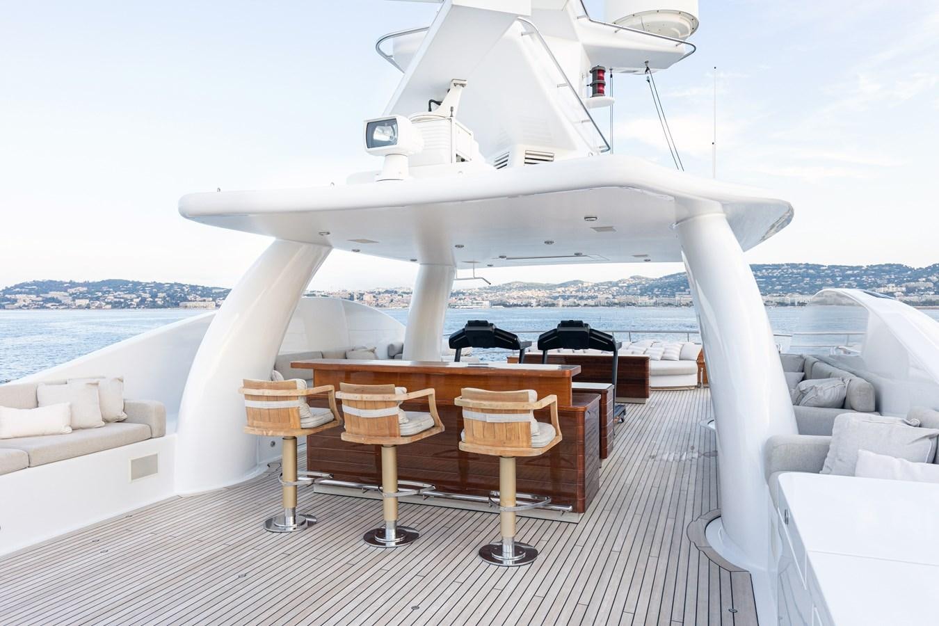 a white boat with a table and chairs on a deck aboard WERE DREAMS Yacht for Sale