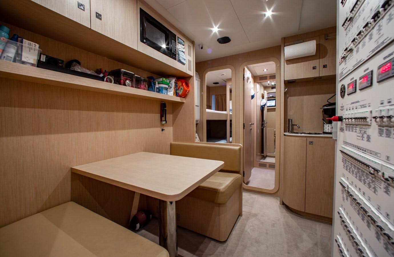 a kitchen with a table and a refrigerator aboard MOVIN DAY Yacht for Sale