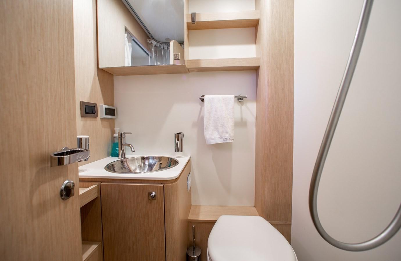 a bathroom with a toilet sink and a mirror aboard MOVIN DAY Yacht for Sale