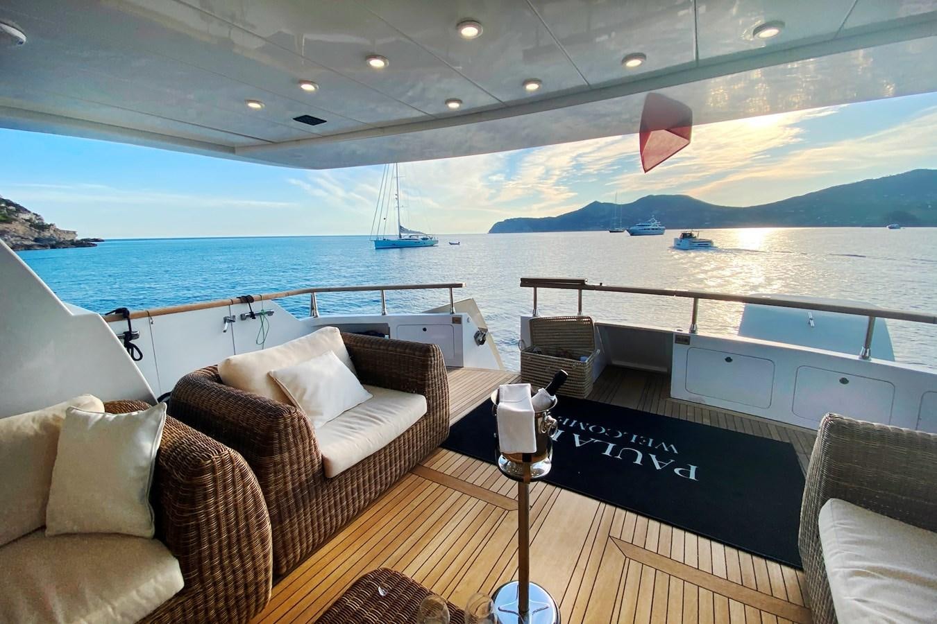 a deck with a view of the ocean and a large ship aboard PAULA III Yacht for Sale