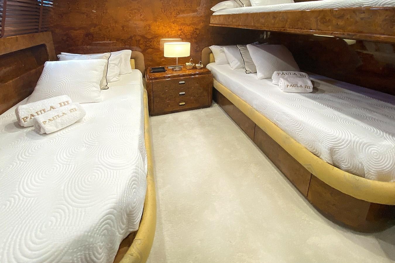 a room with beds and a dresser aboard PAULA III Yacht for Sale