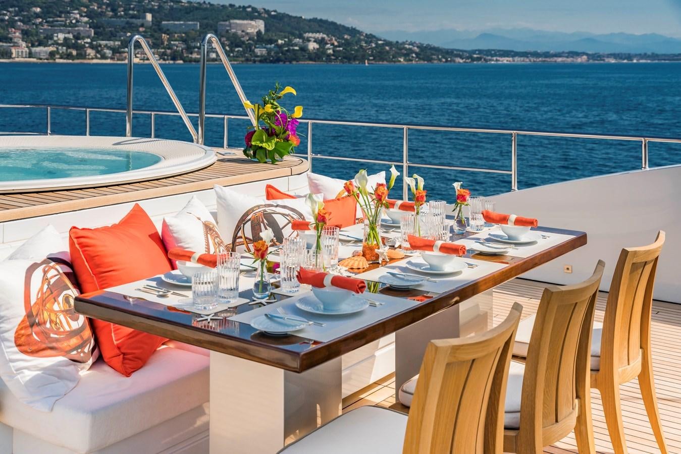a table with food and drinks on it by the ocean aboard TIMBUKTU Yacht for Charter