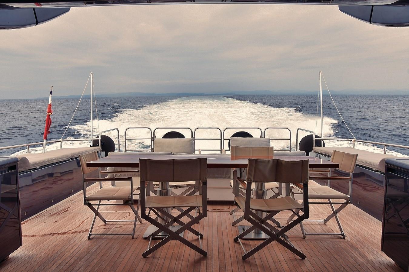 a deck with chairs and tables on it aboard OSE Yacht for Sale